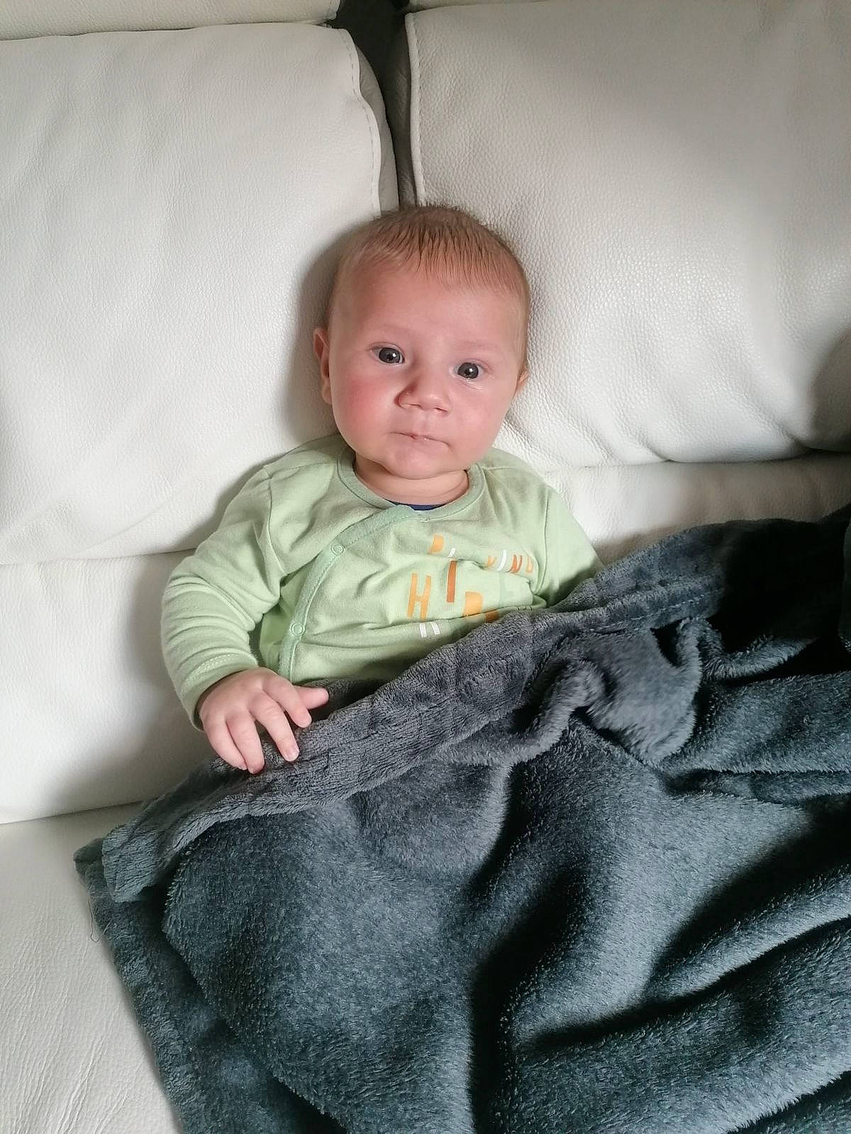 Lucas participe au concours pour gagner de l'argent avec cette photo : baby, baby_products, baby_toddler_clothing, bedding, cheek, child, comfort, couch, flooring, head, linens, pattern, person, room, sitting, sleeve, sock, t_shirt, textile, toddler