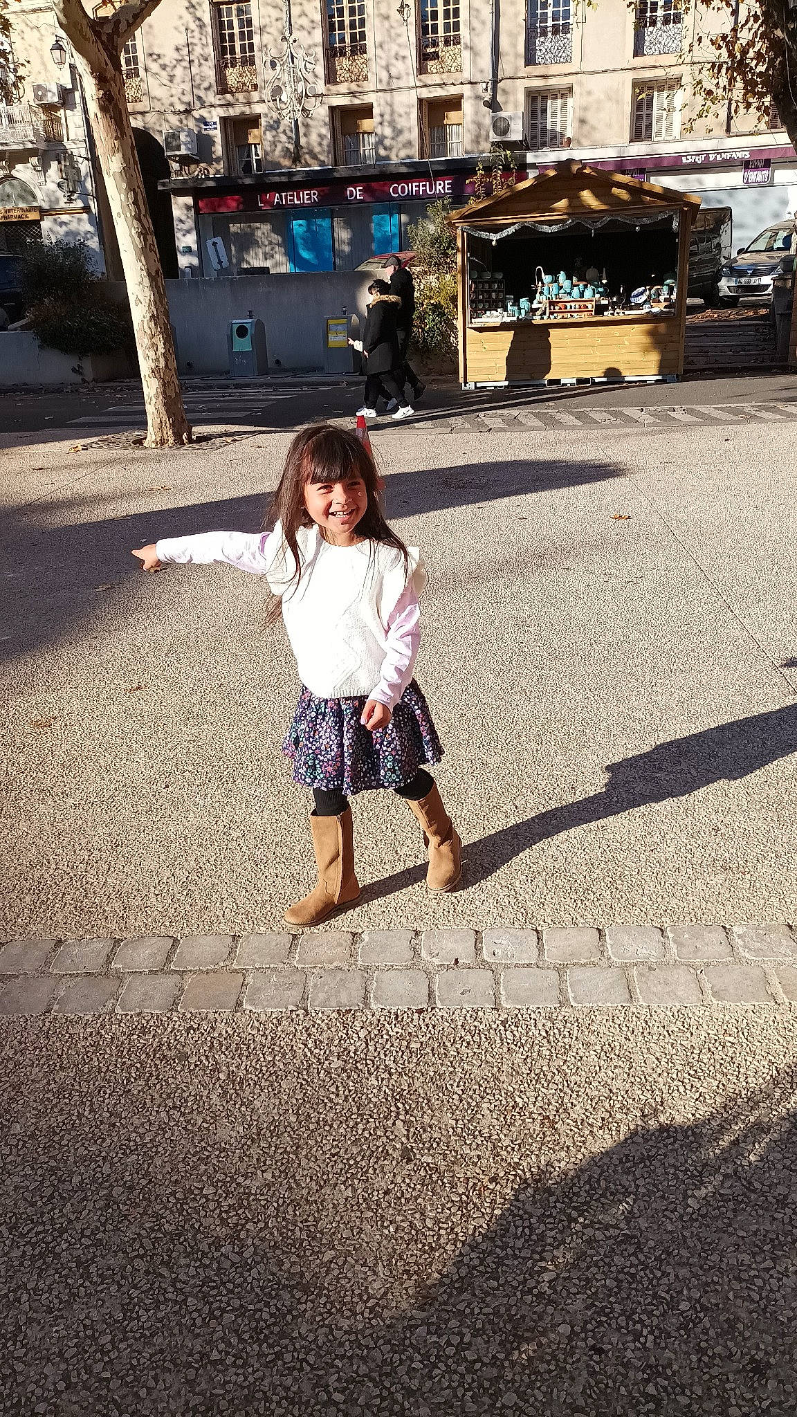 Mia participe au concours pour gagner de l'argent avec cette photo : asphalt, city, denim, dress, flooring, happy, joy, leg, leisure, people_in_nature, person, plant, road, road_surface, sidewalk, standing, street_fashion, tints_and_shades, toddler, tree
