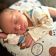 Chris is registered to the contest to win money with this photo: baby, newborn, sleeping, infant, pillow, space_theme, stars, planets, crown, cute, peaceful, soft, clothing, hand, face, portrait, indoors, rest, young, child