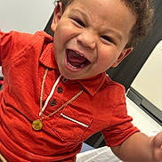 Nekoda joined the competition — help win amazing prizes! child, toddler, smiling, curly_hair, orange_shirt, gold_necklace, happy, indoor, portrait, cute, person, laughing, casual_clothing, young, face, human, joy, emotion, closeup, seated