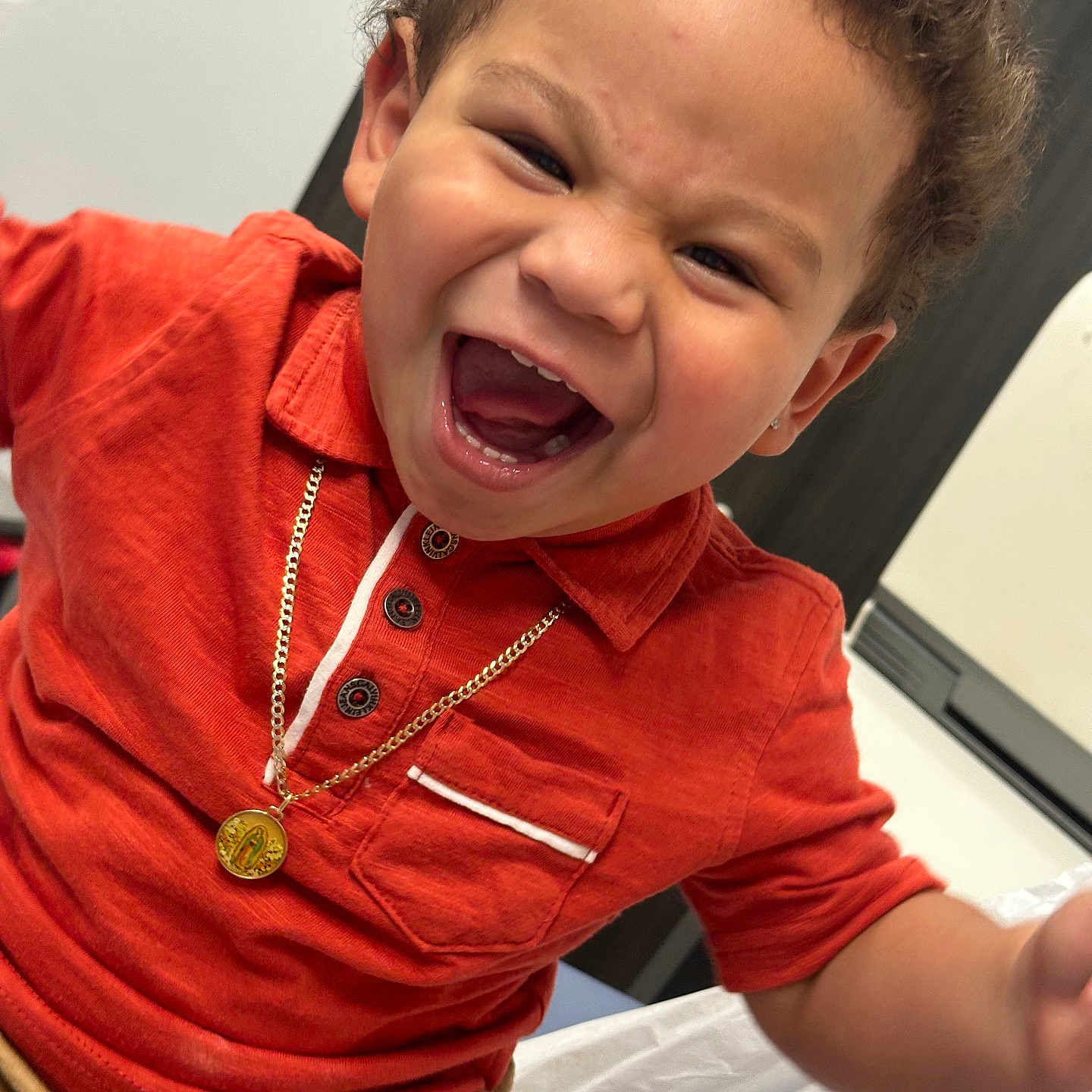 Nekoda joined the competition — help win amazing prizes! casual_clothing, child, closeup, curly_hair, cute, emotion, face, gold_necklace, happy, human, indoor, joy, laughing, orange_shirt, person, portrait, seated, smiling, toddler, young