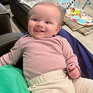 Olivia joined the competition — help win amazing prizes! baby, child, smiling, tongue_out, clothing, indoor, playmat, toy, furniture, person, happy, cute, face, portrait, sitting, cozy, home, infant, relaxed, colorful