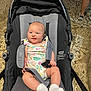 Oaklynn joined the competition — help win amazing prizes! baby, stroller, child, infant, onesie, socks, face, person, seatbelt, outdoor, floor, legs, walking, casual, expression, cute, colorful, resting, comfort, young