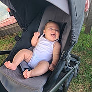 Oaklynn joined the competition — help win amazing prizes! baby, stroller, outdoor, grass, white_onesie, tongue_out, happy, infant, seat, playful, sunlight, child, person, relaxing, summer, casual, expression, cute, baby_boy, wheeled_vehicle