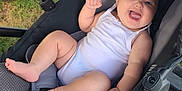 Oaklynn is registered to the contest to win money with this photo: baby, smile, stroller, white_onesie, infant, happy, outdoor, grass, hand, foot, face, person, seat, fabric, baby_clothing, baby_toddler, cute, child, cheerful, summer