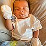 baby, newborn, sleeping, white_shirt, mittens, blanket, cushion, infant, peaceful, cozy, indoors, child, face, head, resting, soft_texture, cute, small, person, relaxation
