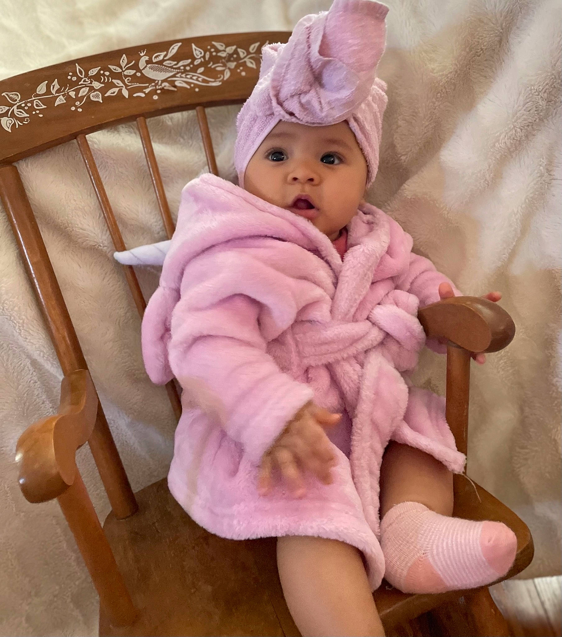 Jahzara is registered to the contest to win money with this photo: baby, baby_products, baby_toddler_clothing, cap, chair, comfort, eye, headgear, headwear, human_body, lap, linens, magenta, person, pink, purple, sleeve, sock, thigh, thumb
