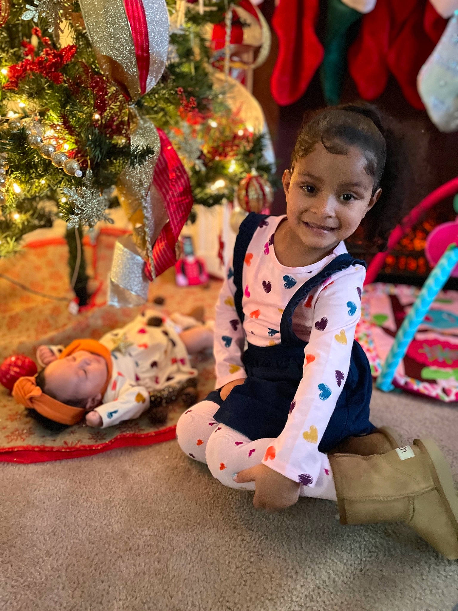 Jaliyah is registered to the contest to win money with this photo: baby_toddler_clothing, child, christmas_decoration, christmas_ornament, christmas_tree, event, facial_expression, fun, happy, head, holiday, holiday_ornament, joy, leisure, ornament, person, plant, sitting, smile, toddler
