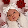 baby, infant, white_bow, fluffy_vest, red_roses, pink_background, cute, newborn, portrait, face, headwear, soft_texture, small_fists, lying_down, closeup, adorable, baby_clothing, decorative_flowers, innocent, expression