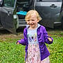 child, smiling, blonde_hair, purple_jacket, butterfly_dress, grass, outdoor, car, open_car_door, happy, young_girl, playful, casual_clothing, daylight, nature, portrait, childhood, cute, joy, fun