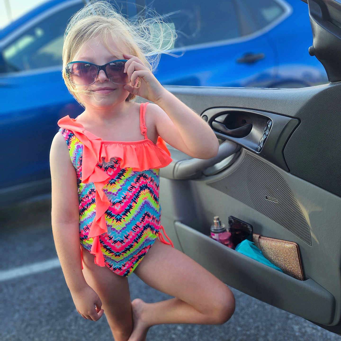 Lunah joined the competition — help win amazing prizes! asphalt, barefoot, blonde_hair, car, casual, child, colorful_clothing, fun, girl, open_car_door, outdoor, parking_lot, playful_pose, smile, summer, sunglasses, sunlight, swimsuit, wind, young