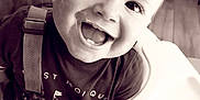 Nino participe au concours pour gagner de l'argent avec cette photo : baby, black_and_white, child, close_up, clothing, eyes, face, hair, happy, high_chair, indoor, messy_face, mouth, person, portrait, seat, smiling, teeth, toddler, wood_floor