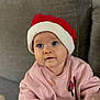 baby, child, santa_hat, pink_sweater, minnie_mouse, blue_eyes, cute, indoor, couch, cozy, holiday, festive, portrait, smiling, clothing, infant, face, young_child, seated, soft_lighting