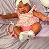 baby, child, infant, headband, bow, pink_clothing, white_socks, pacifier_clip, bed_sheet, lavender, lying_down, happy, smiling, cute, skin, arms, legs, indoors, person, portrait