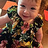 Myonie joined the competition — help win amazing prizes! baby, child, smiling, dress, floral_pattern, orange_placemat, wooden_table, indoors, cute, happy, sitting, face, person, skin, hair, table, plaid, expression, infant, toddler