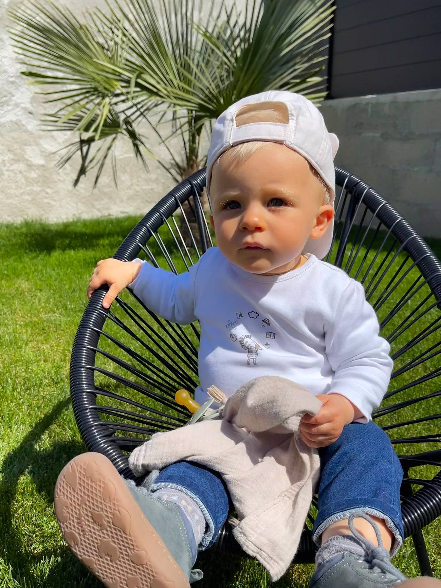Nélio participe au concours pour gagner de l'argent avec cette photo : baby_toddler_clothing, child, clothing, grass, green, happy, hat, leaf, leg, leisure, people_in_nature, person, photograph, plant, recreation, shoe, sitting, sneakers, toddler, tree