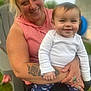 Bonnie is registered to the contest to win money with this photo: woman, baby, smile, tattoo, outdoor, child, person, clothing, face, hand, ring, grass, chair, happy, casual, nature, portrait, holding, baby_clothes, daylight