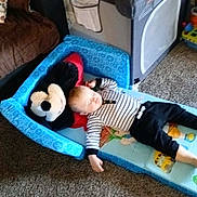 Jaxton is registered to the contest to win money with this photo: baby, black_pants, carpet, child, couch, face, floor, head, infant, living_room, mattress, nap, pillow, playmat, playpen, sleeping, soft_toy, striped_clothing, stuffed_animal, toy_block