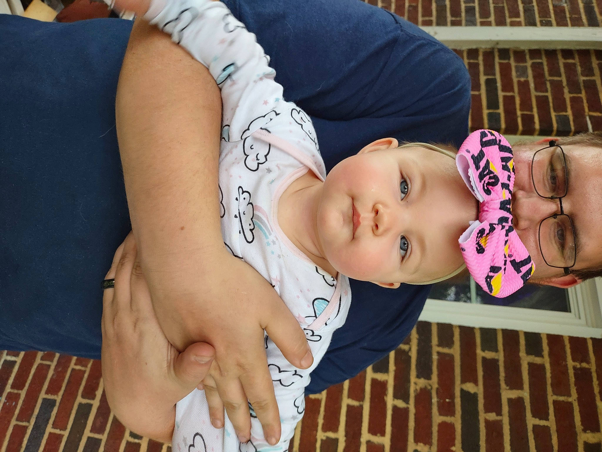 Haylee is registered to the contest to win money with this photo: abdomen, baby, black_hair, chest, child, elbow, eyewear, glasses, grass, happy, hat, headwear, human_leg, joint, knee, person, plant, skin, thigh, toddler