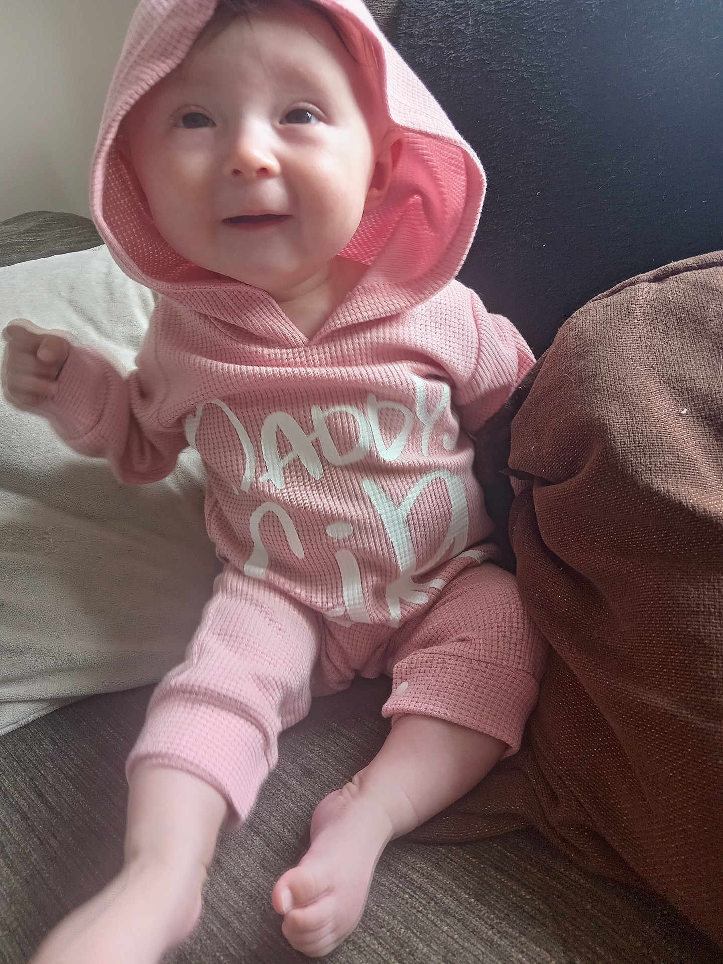 Azzalia joined the competition — help win amazing prizes! baby, child, pink_hoodie, sitting, couch, pillow, indoors, face, expression, clothing, foot, hand, comfort, cute, infant, hood, text_on_clothing, soft_lighting, person, portrait