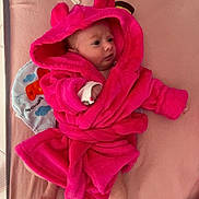 Lyana a rejoint le concours — aidez-le/la à gagner de superbes lots ! baby, infant, pink_robe, hood, soft_toy, blanket, mattress, bed, cute, child, newborn, lying_down, clothing, indoors, toy, colorful, expression, face, hand, foot