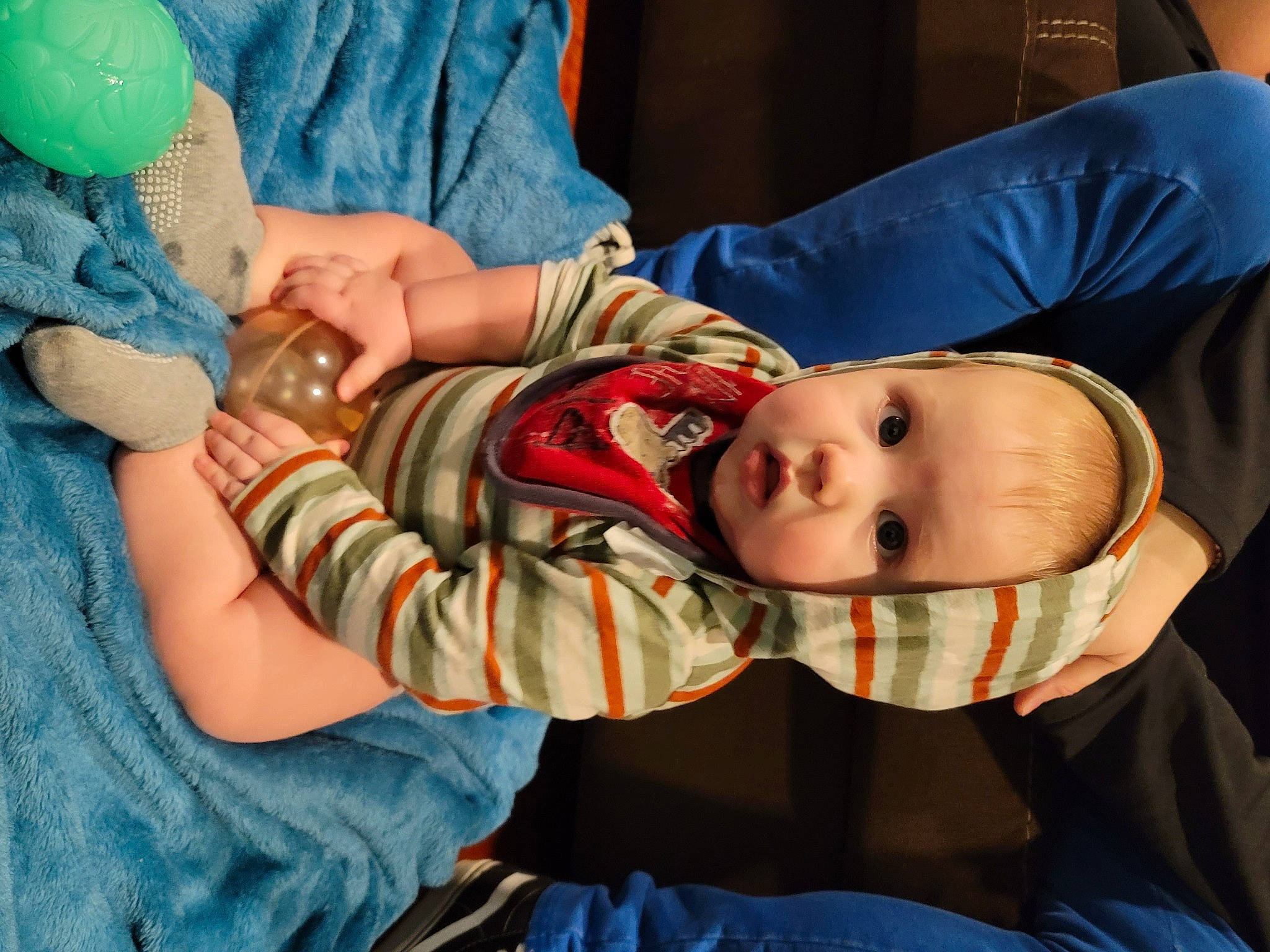 Gavin is registered to the contest to win money with this photo: abdomen, baby, baby_products, baby_toddler_clothing, blue, cheek, child, comfort, elbow, fun, gesture, human_body, mouth, nail, pattern, person, room, sitting, skin, sleeve