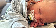 Jaxson is registered to the contest to win money with this photo: baby, sleeping, pacifier, hoodie, infant, hand, face, cozy, rest, closeup, soft, skin, child, peaceful, candid, indoors, newborn, comfort, casual, portrait