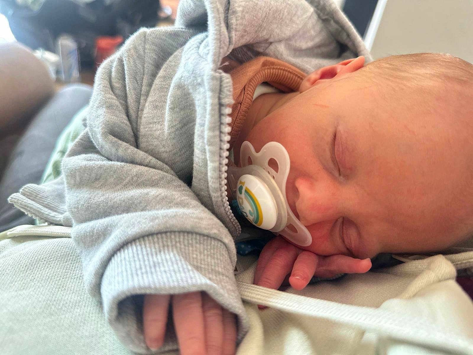 Jaxson is registered to the contest to win money with this photo: baby, sleeping, pacifier, hoodie, infant, hand, face, cozy, rest, closeup, soft, skin, child, peaceful, candid, indoors, newborn, comfort, casual, portrait