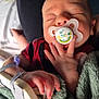 Jaxson is registered to the contest to win money with this photo: baby, sleeping, pacifier, hand, blanket, iv_line, medical, person, lap, red_clothing, green_blanket, infant, closeup, indoors, soft_texture, resting, newborn, comfort, skin, peaceful