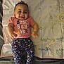 baby, smiling, infant, milestone_blanket, pink_shirt, floral_leggings, numbers, text, lying_down, cute, child, happy, portrait, feet, arms, indoor, fabric, calendar, months, person