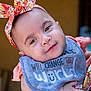 baby, child, infant, headband, bib, smile, face, person, adult_hand, clothing, portrait, closeup, cute, holding, floral_pattern, colorful, happy, young, people, outdoor
