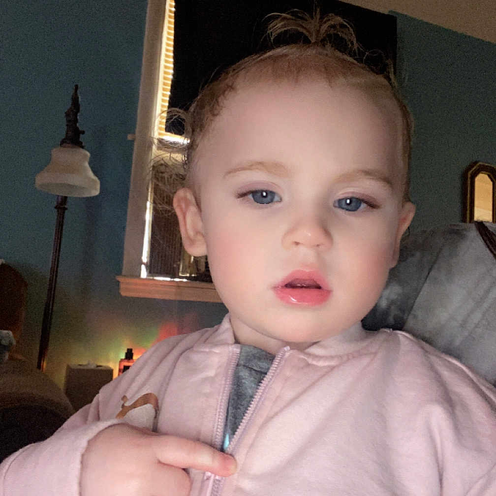 Nova joined the competition — help win amazing prizes! background, blue_eyes, casual_clothing, child, cozy_room, curtain, expression, face, finger_pointing, hair, hand, indoor, lamp, light, person, pink_jacket, portrait, toddler, window, young_child