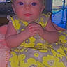 Dakota is registered to the contest to win money with this photo: baby, child, yellow_dress, floral_pattern, indoor, portrait, smiling, hands_clasped, blue_eyes, soft_lighting, window, cozy, seated, infant, cute, expression, clothing, person, face, home