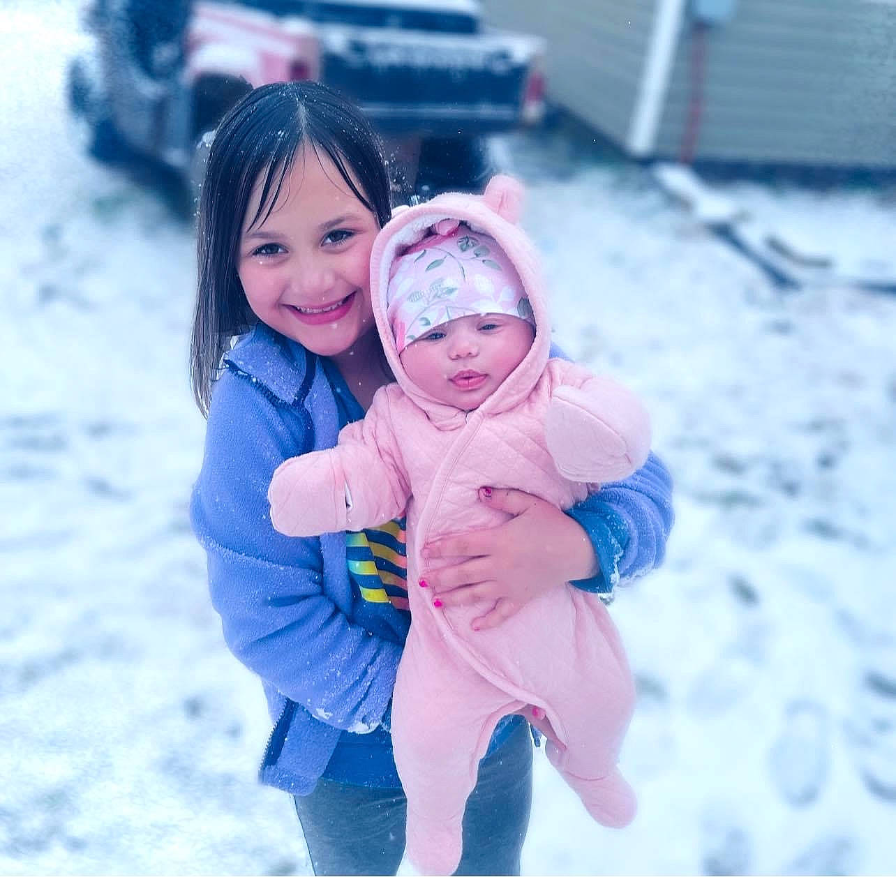 Mckinley is registered to the contest to win money with this photo: baby_toddler_clothing, car, freezing, friendship, fun, gesture, glove, grass, happy, headwear, human_body, jacket, joy, leisure, people, people_in_nature, person, playing_with_kids, recreation, snow