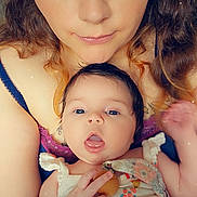 Marie participe au concours pour gagner de l'argent avec cette photo : woman, baby, face, portrait, closeup, indoor, person, cute, expression, holding, clothing, pattern, heart_emoji, skin, hair, eyes, baby_clothes, mother, child, love