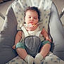 baby, baby_clothing, baby_seat, child, cushion, cute, dandelion_pattern, face, green_pants, head, heart_emoji, indoor, infant, pacifier, peaceful, sleeping, soft_lighting, straps, white_socks, wooden_floor