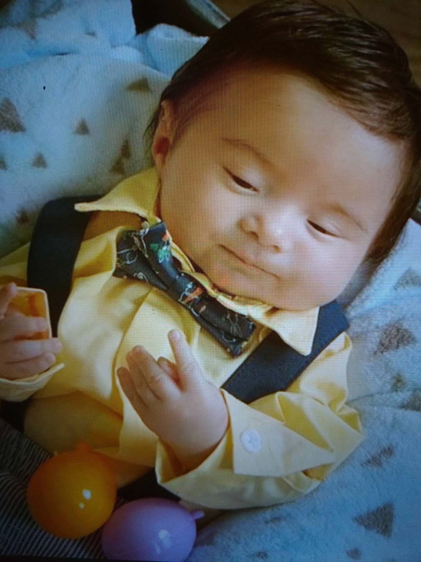 Troy is registered to the contest to win money with this photo: baby, baby_products, baby_toddler_clothing, balloon, cheek, child, comfort, event, facial_expression, finger, happy, linens, nose, party_supply, pattern, person, sitting, skin, textile, toddler