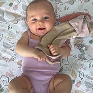 Cataleya a rejoint le concours — aidez-le/la à gagner de superbes lots ! baby, infant, child, smiling, blanket, pattern, soft_toy, clothing, sleeveless, skin, barefoot, lying_down, indoors, floor, happy, cute, playful, face, person, young