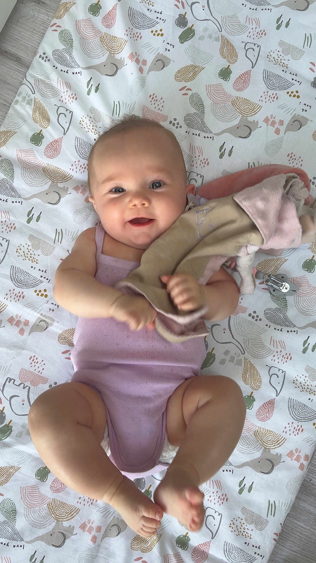 Cataleya a rejoint le concours — aidez-le/la à gagner de superbes lots ! baby, infant, child, smiling, blanket, pattern, soft_toy, clothing, sleeveless, skin, barefoot, lying_down, indoors, floor, happy, cute, playful, face, person, young