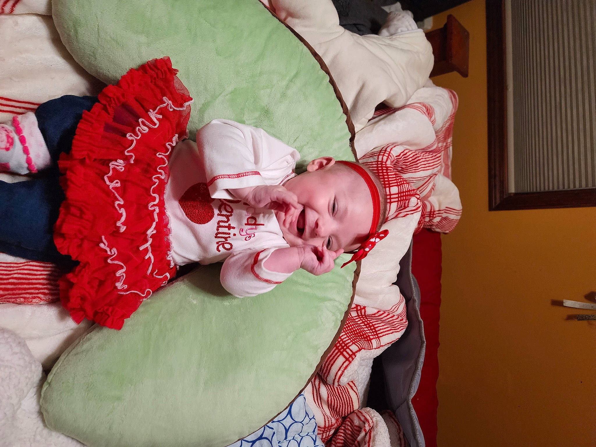 Dakota is registered to the contest to win money with this photo: baby, baby_products, baby_toddler_clothing, carmine, child, christmas_eve, comfort, couch, event, eye, face, facial_expression, head, headwear, human_body, lap, person, pillow, room, sitting