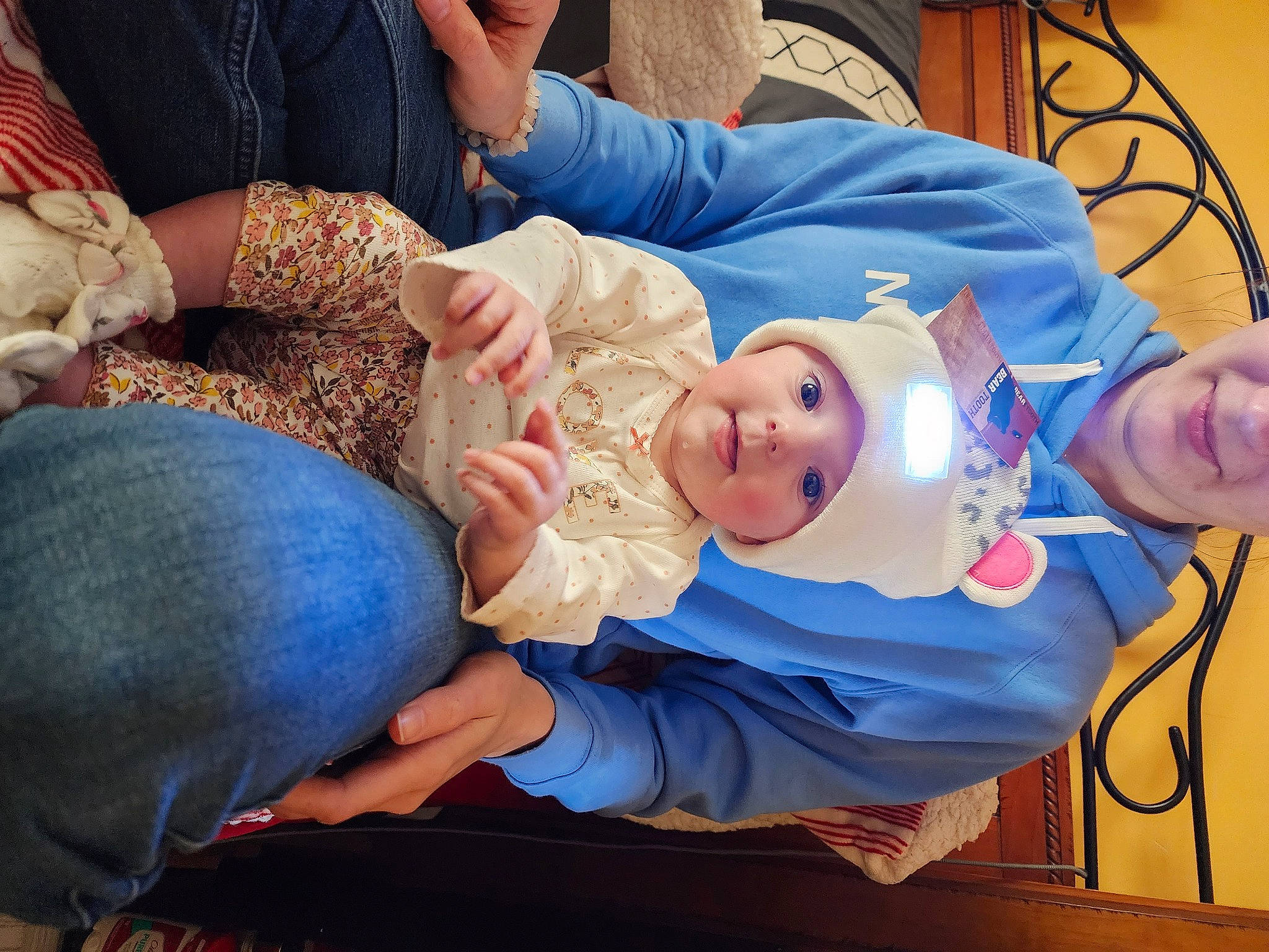 Dakota is registered to the contest to win money with this photo: arm, baby, child, comfort, event, finger, fun, hand, hat, headwear, health_care, hospital, joint, lap, medical, medical_procedure, mouth, organ, person, service