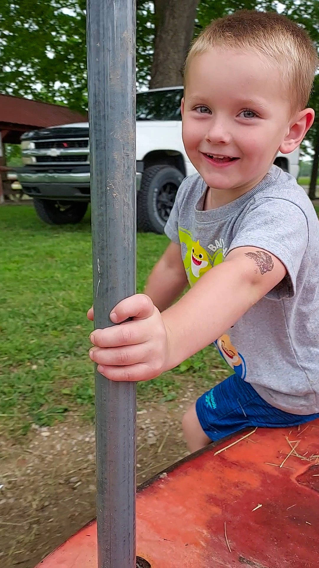 Hudson is registered to the contest to win money with this photo: automotive_tire, automotive_wheel_system, car, eye, finger, fun, grass, hand, happy, joy, leisure, person, plant, smile, thumb, tire, toddler, tree, vehicle, vehicle_door