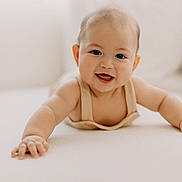 Charlie is registered to the contest to win money with this photo: baby, smiling, crawling, child, infant, cute, happy, face, skin, hand, arm, indoors, soft_light, portrait, young, person, clothing, closeup, expression, background_blur