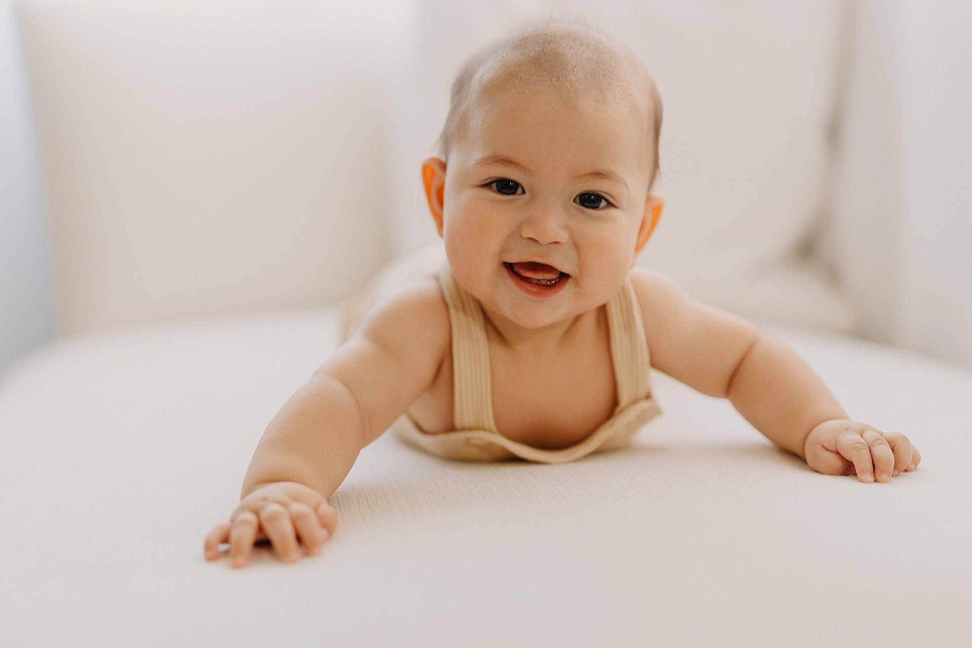 Charlie is registered to the contest to win money with this photo: baby, smiling, crawling, child, infant, cute, happy, face, skin, hand, arm, indoors, soft_light, portrait, young, person, clothing, closeup, expression, background_blur