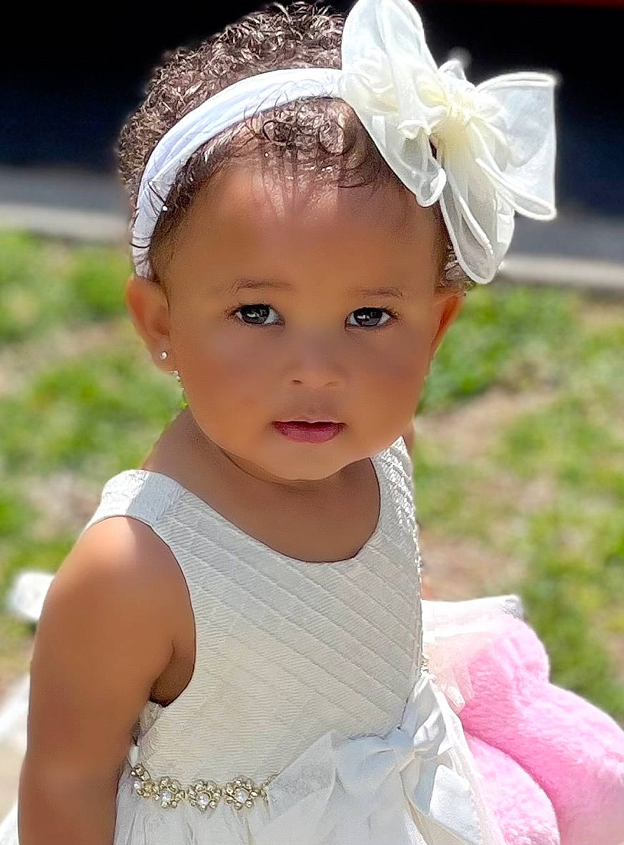 Kali joined the competition — help win amazing prizes! baby_toddler_clothing, beauty, bridal_accessory, child, clothing, dress, embellishment, eyelash, flash_photography, grass, happy, headband, headgear, headpiece, headwear, person, petal, photograph, pink, summer