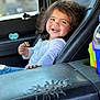Jazmynn is registered to the contest to win money with this photo: child, toddler, smile, cookie, car_seat, car_interior, pacifier, cup_holder, seat, clothing, jewelry, happy, hair, hand, window, leather, portrait, seatbelt, person, indoor
