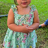 Jazmynn joined the competition — help win amazing prizes! child, toddler, girl, dress, floral_pattern, outdoor, grass, shoes, sandals, necklace, person, cute, smile, standing, greenery, daylight, curly_hair, nature, portrait, happy