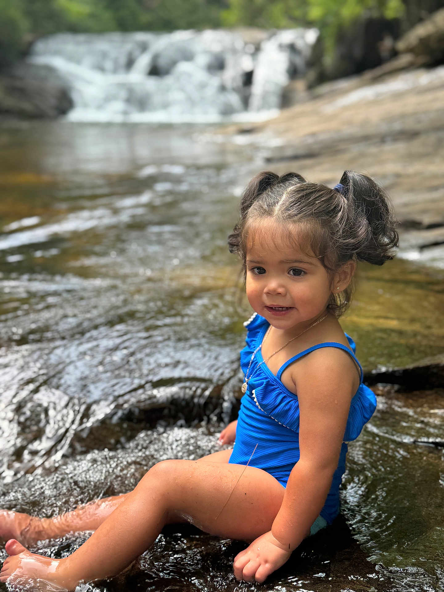Jazmynn joined the competition — help win amazing prizes! child, toddler, girl, swimsuit, blue, water, stream, waterfall, outdoor, nature, sitting, pigtails, smiling, summer, necklace, rocks, sunlight, play, happy, portrait