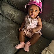 Jace joined the competition — help win amazing prizes! baby, bucket_hat, casual_clothing, child, comfortable, couch, curious_expression, cute, floral_hat, gray_couch, home, indoors, infant, open_mouth, pink_outfit, pink_socks, portrait, seated, wide_eyes, young_child