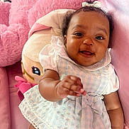 Tavare Thrasher joined the competition — help win amazing prizes! baby, child, smiling, dress, blue, white, checkered, couch, pink, plush_toy, pillow, soft, indoor, happy, person, infant, cute, portrait, hand, curly_hair